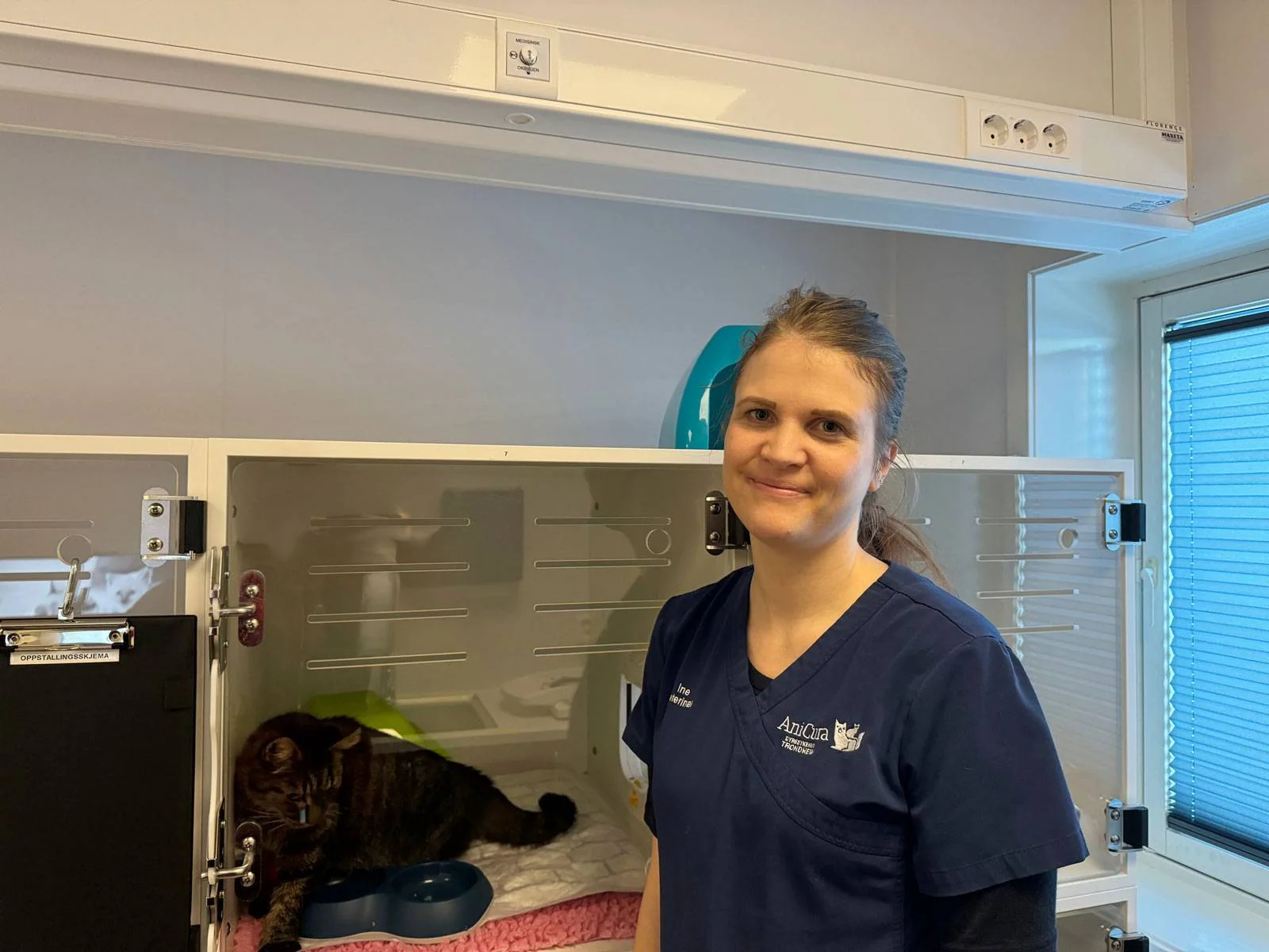 Bildet viser veterinær Ine Sund sammen med en katt på Anicura dyresykehus på Tiller.