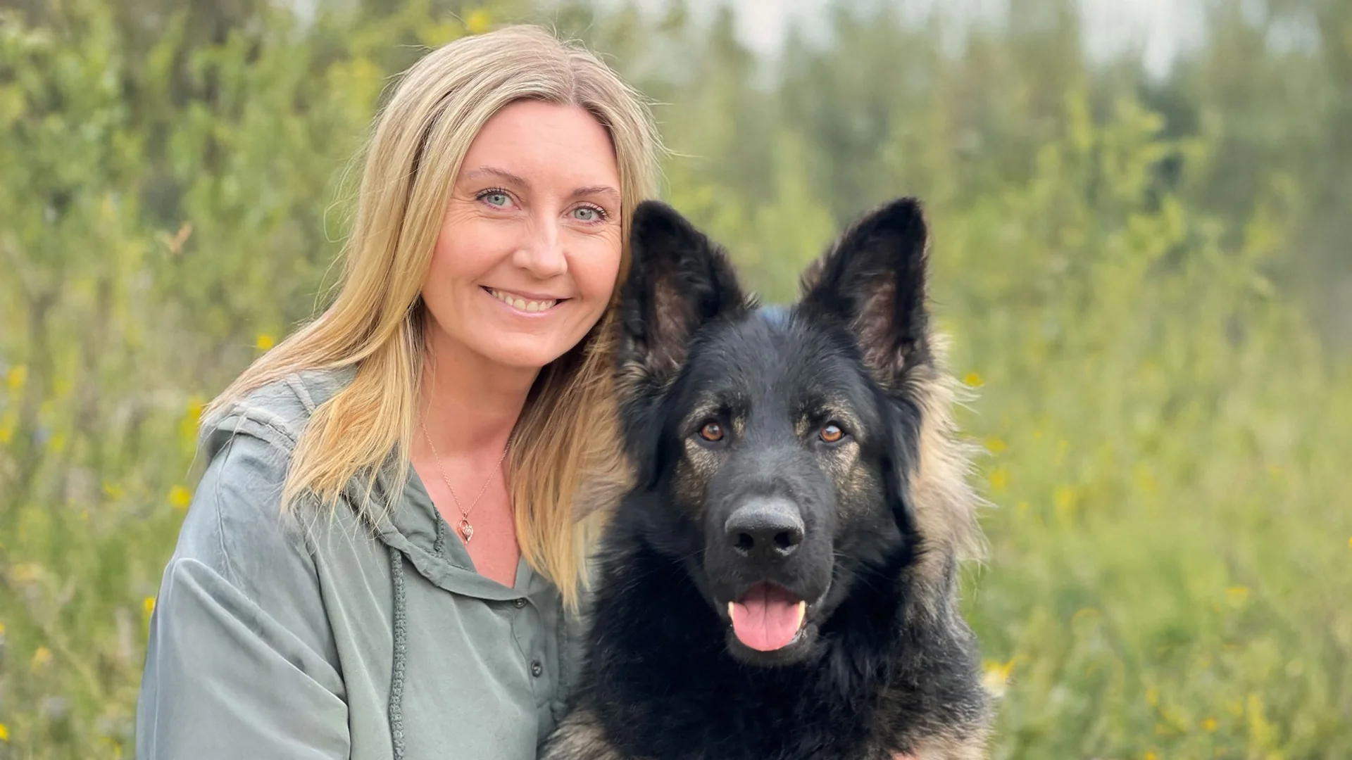 Christine Olsen sitter ute sammen med en hund.