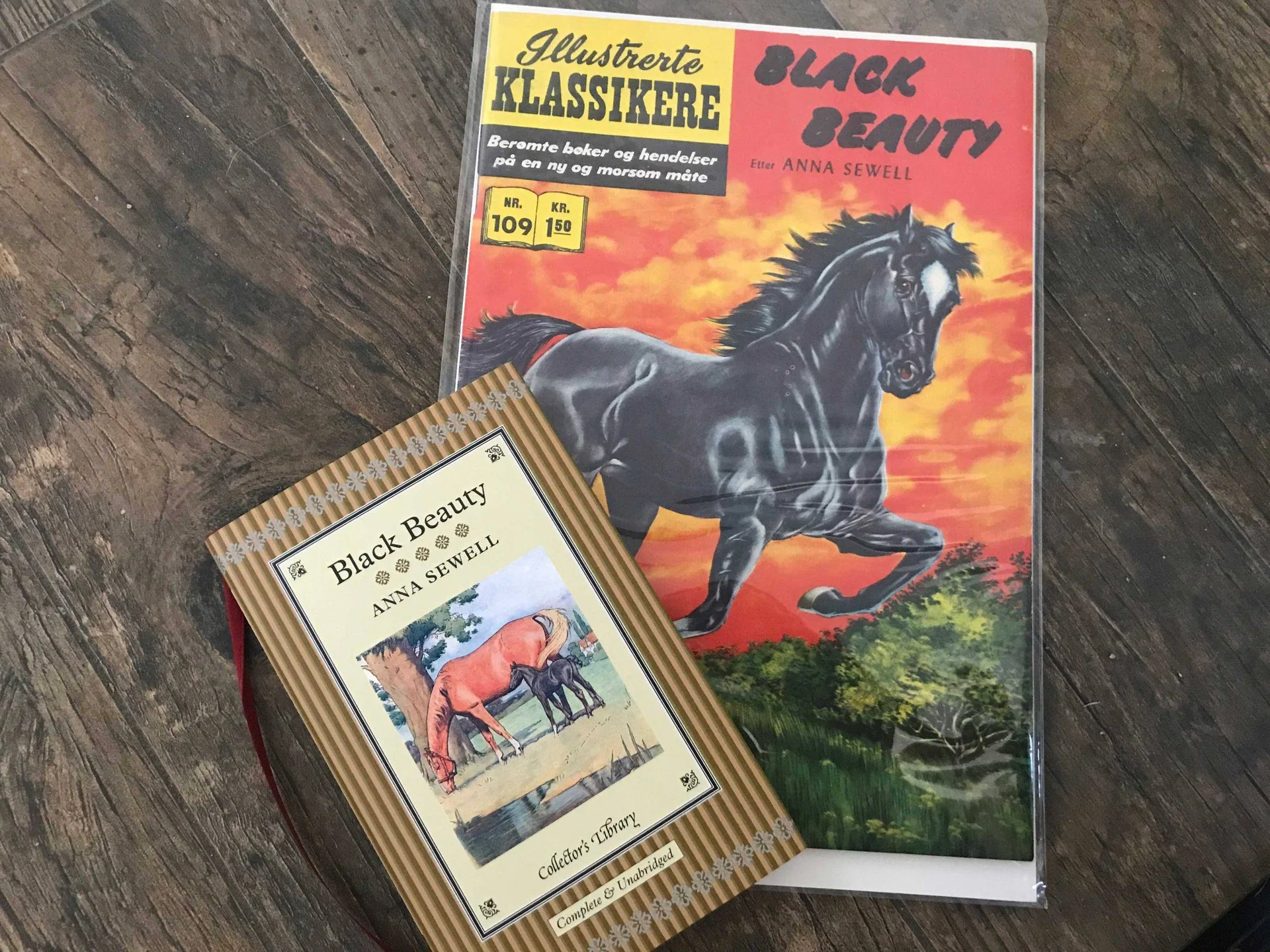 To utgaver av «Black Beauty» ligger på et tregulv.