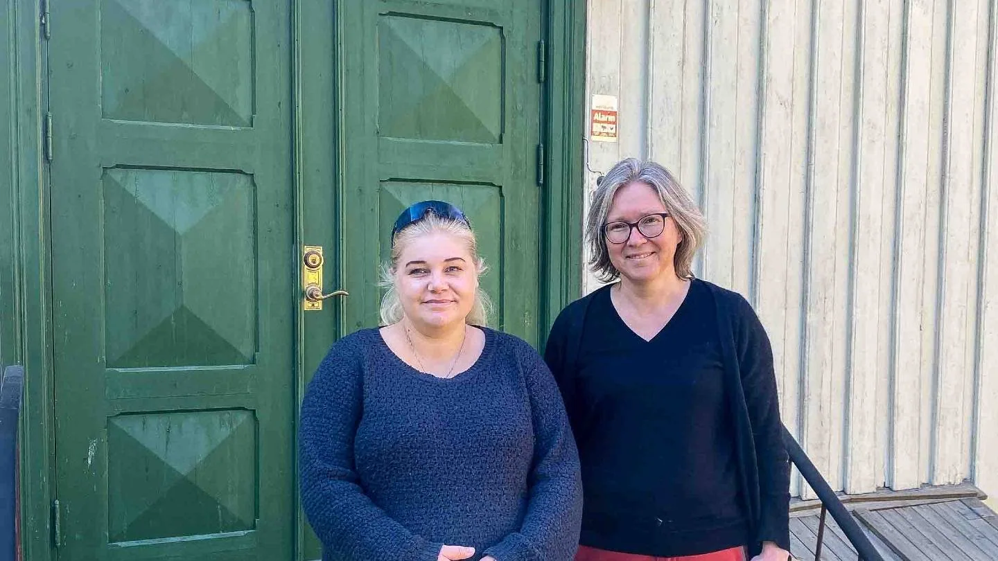 Linda Krokstad og Anita Fossdal står foran en grønn dør.