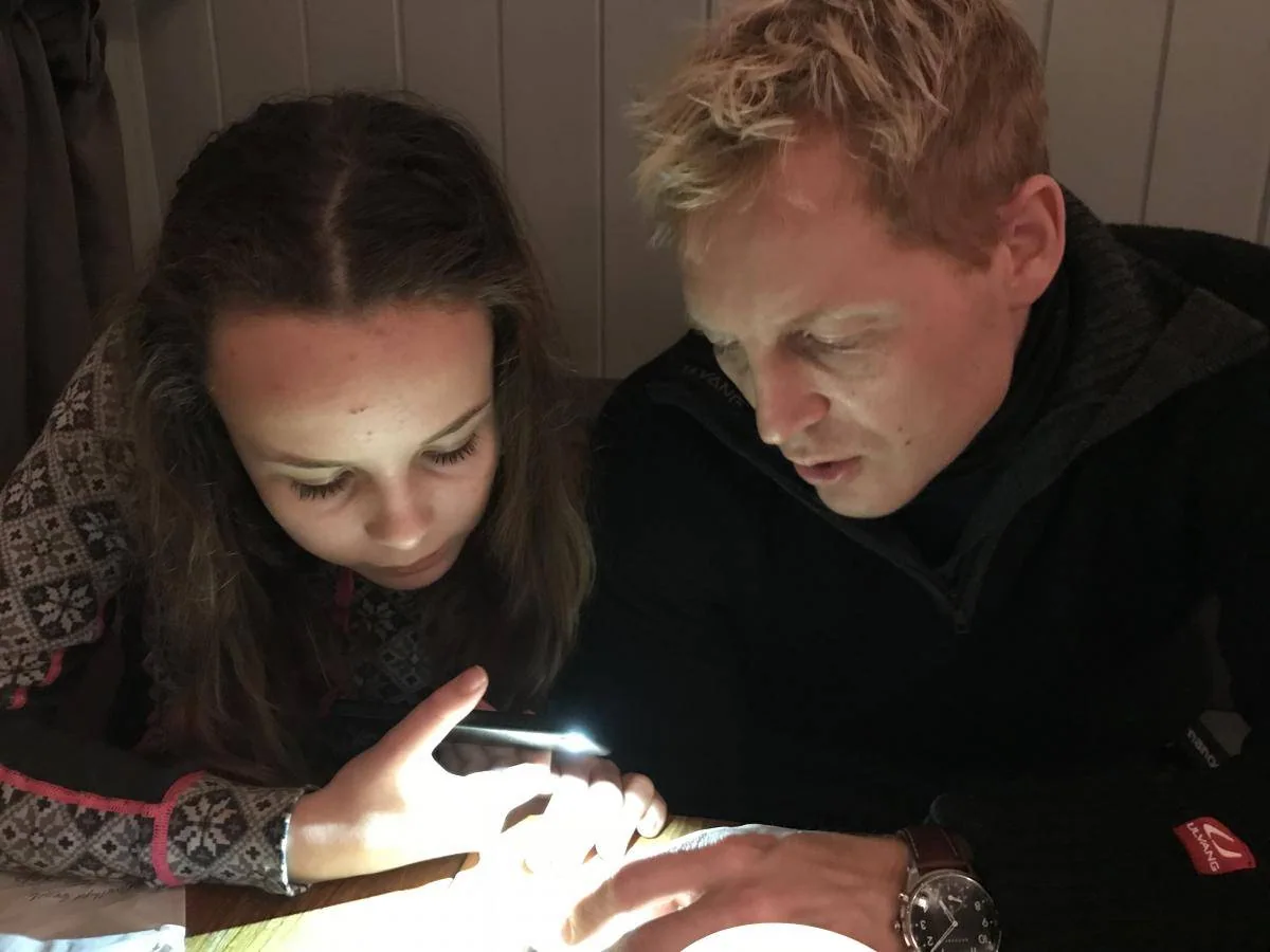 Et barn og en mann ser sammen på en lysende skjerm.