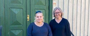 Linda Krokstad og Anita Fossdal står foran en grønn dør.