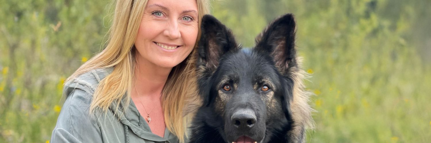 Christine Olsen sitter ute sammen med en hund.