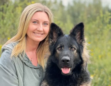 Christine Olsen - Dyr og folk Christine Olsen sitter ute sammen med en hund.